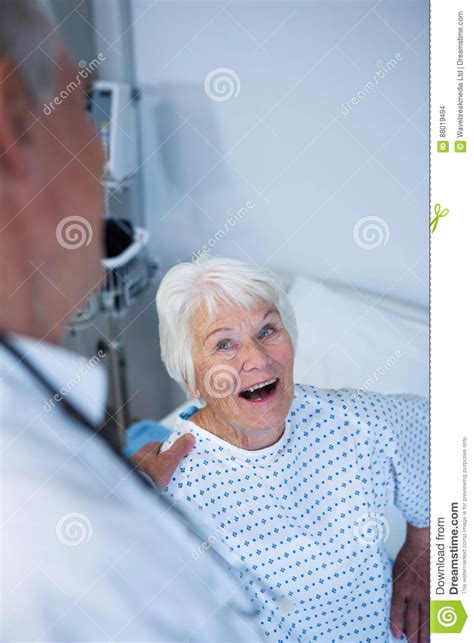 Doctor Interacting With Senior Patient In Ward Stock Photo Image Of