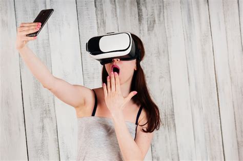 Une Jolie Fille Portant Des Lunettes Vr Tenant Son Téléphone Avec Enthousiasme Devant Son