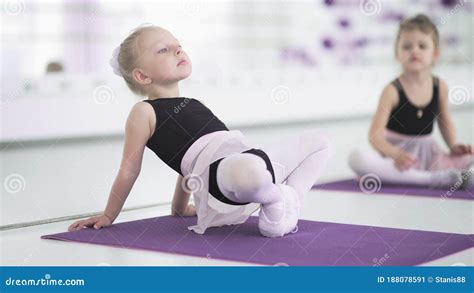 Little Girls Stretching And Doing Exercises In Ballet School Stock