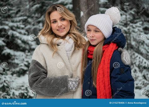 Beautiful Blonde Mom In A Fur Coat And Her Teenage Daughter Pose For A
