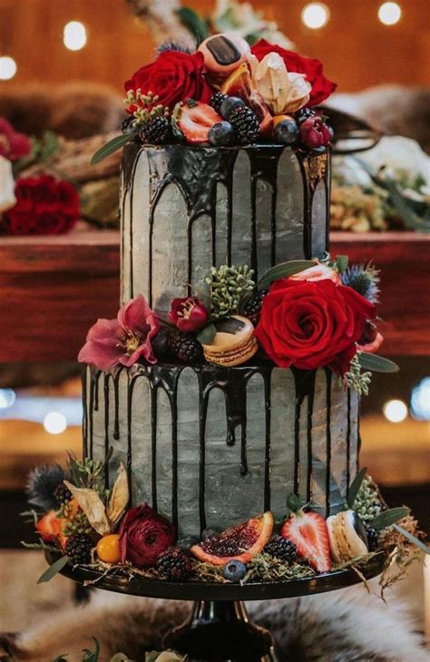 A Three Tiered Cake Decorated With Flowers And Berries