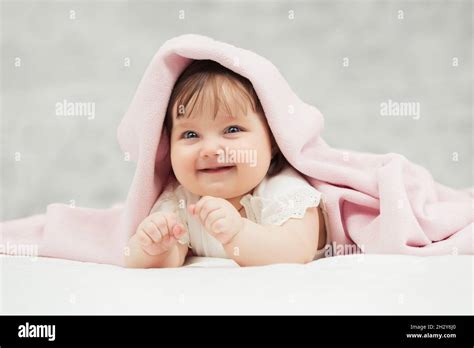 Little Girl Lying On Bed Playing With Baby Girl Hi Res Stock