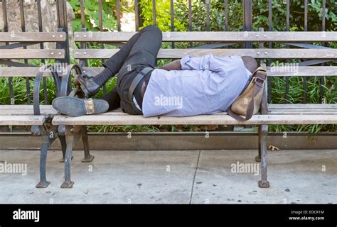 A Man Sleeping On A City Park Bench Stock Photo Alamy