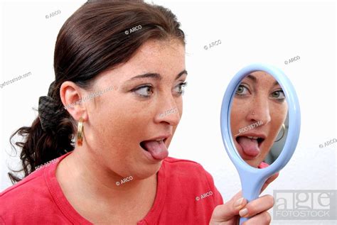 Young Woman Regarding Her Coated Tongue In Mirror Furred Tongue