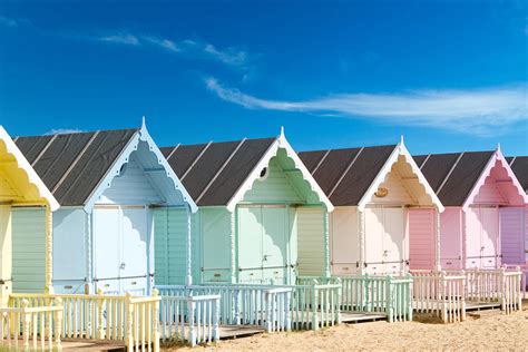 Traditional British Beach Huts On A Bright Sunny Day Photograph By