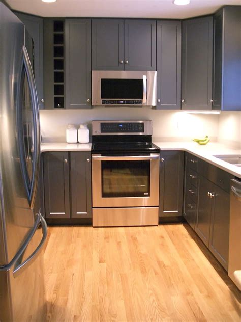 Charcoal gray french kitchen cabinets are complemented with brass hardware and a marble countertop holding a sink with an antique brass gooseneck antique brass hardware complements white kitchen cabinetry topped with a gray quartzite countertop flanking a stainless steel oven range. Dark gray cabinets with white quartz countertops | Kitchen ...