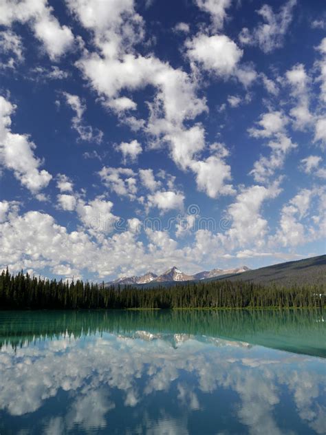 Mountains And Clouds Reflected In A Mountain Colored Lake Stock Image