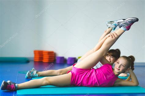 Two Girls Doing Yoga Stretching In Fitness Class Stock Photo By