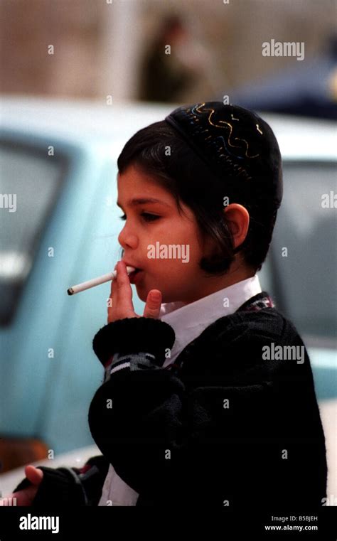 A Small Boy Smokes A Cigarette During The Colorful Purim Festival Stock