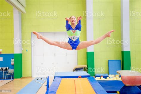 Young Smiling Gymnastics Athlete Doing The Splits In Mid Air Stock