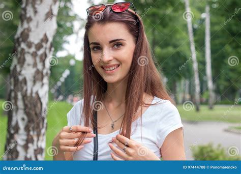 Portrait Of Beautiful Cheerful Girl Smiles On Camera With Sunglasses On