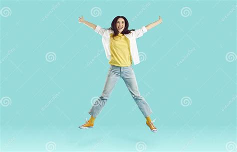Cheerful Funny Woman Joyfully Jumps Spreading Arms And Legs On Vivid