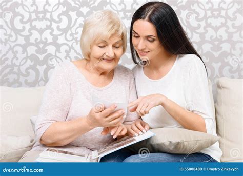 Nieta Y Su Abuelita Que Miran Las Fotos Foto De Archivo Imagen De