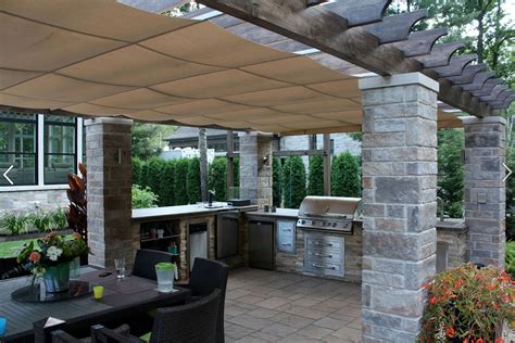 Covered outdoor stone kitchen with patio dining area. 'Gimme Shelter': The ShadeFX Retractable Canopy