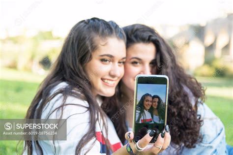 Friends Taking A Selfie Friends Taking A Selfie On A Phone Superstock
