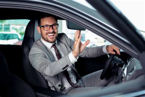Handsome Businessman Is Sitting In A New Car In Car Dealership Stock