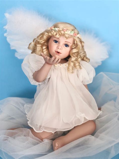 A Doll With Blonde Hair And Blue Eyes Sitting On A White Tulle Skirt