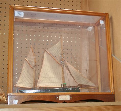 A Model Of A Two Masted Fishing Boat Within A Display Case Inscribed