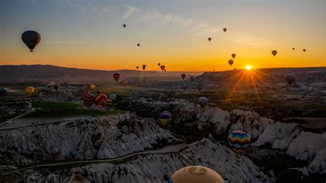 Download Wallpaper 1366x768 Air Balloons Mountains Sunrise Aerial View Landscape Tablet