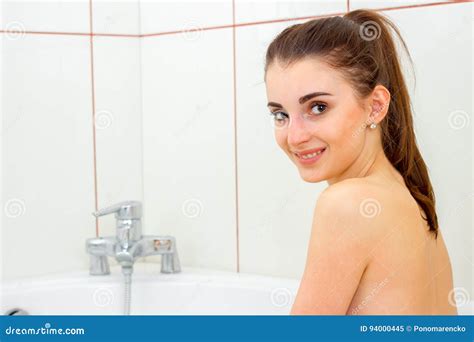 Cute Young Girl Bathed In The Bathtub And Smiles At The Camera Stock