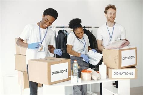 Two Boys And A Girl Volunteers Pack Humanitarian Aid Stock Image