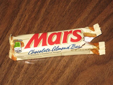 Mars Chocolate Almond Bar Sitting On Top Of A Wooden Table