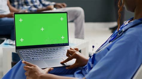 Medical Assistant Looking At Wireless Pc With Greenscreen Stock Photo