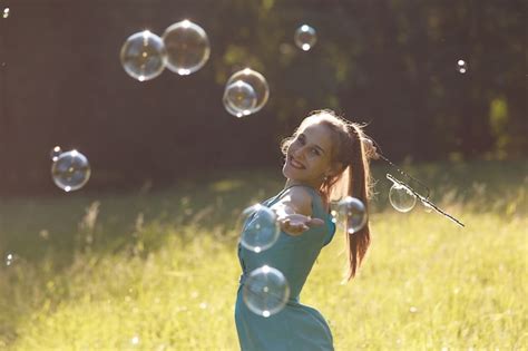 Premium Photo A Girl Makes Big Soap Bubbles In The Park