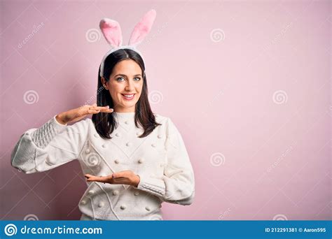 Young Caucasian Woman Wearing Cute Easter Rabbit Ears Over Pink