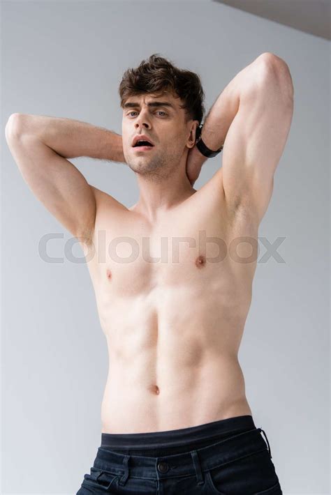 Sexy Shirtless Man With Hands Up Looking At Camera On Grey Stock Image Colourbox