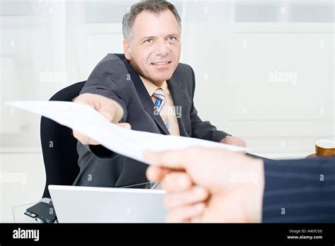 Businessman Handing Over A Piece Of Paper Stock Photo Alamy