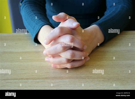 Palms Folded In Prayer Clasped Fingers Girl Sits And Holds Hands In