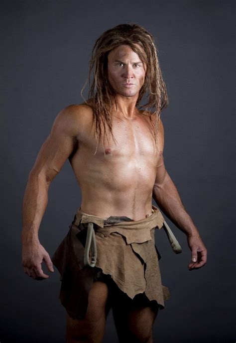 A Man With Dreadlocks And No Shirt Is Posing For A Photo In Front Of A Dark Background