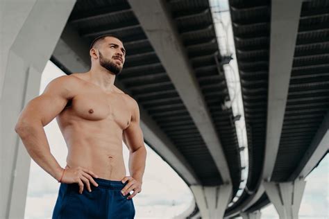 Strong Man With Naked Torso Keeps Hands On Waist Has Muscular Body After Long Training Focused
