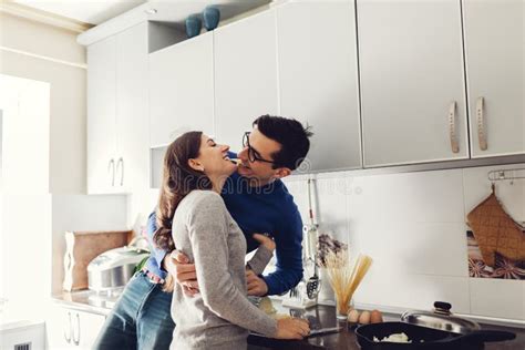 Happy Young Couple Hugging On Kitchen Woman Sitting On Table Stock