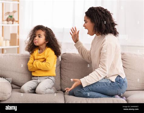 Madre Enojada Gritando A Su Hija Sentado En Un Sofá En Casa Fotografía