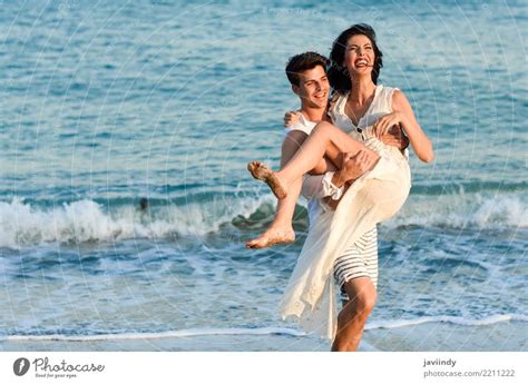 Young Happy Couple Walking In A Beautiful Beach A