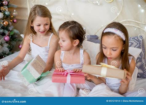 Child Girls Wake Up In Their Bed In Christmas Morning Stock Photo