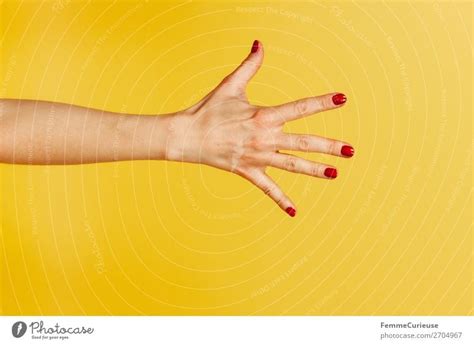 Forearm Hand And Index Finger Against A Yellow Background A Royalty