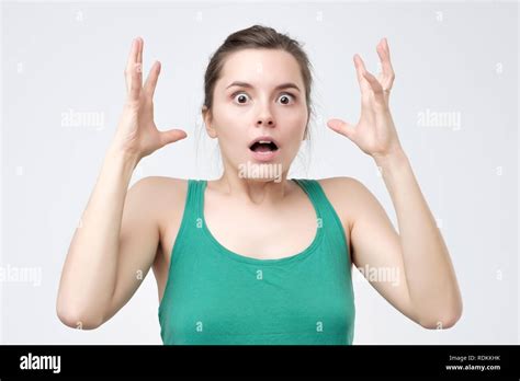 Surprised Young Woman Shouting In Anger Over Gray Background Stock