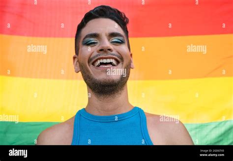 hombre homosexual feliz celebrando el orgullo gay sosteniendo el símbolo de la bandera del arco