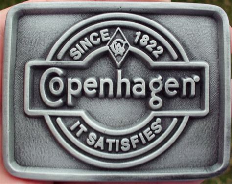 Copenhagen snuff sign dated 2004 u.s.smokeless tobacco co. COPENHAGEN SNUFF IT SATISFIES BELT BUCKLE