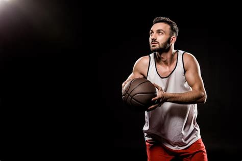 Premium Photo Serious Basketball Player Holding Ball On Black Background