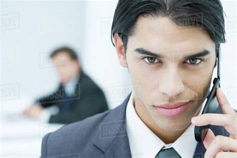 Young Professional Man Holding Cell Phone Smirking At Camera Portrait