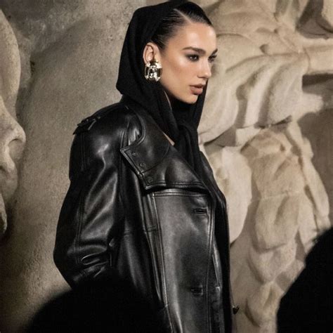 A Woman Wearing A Black Leather Jacket And Silver Earrings