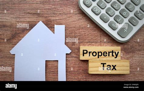 Property Tax Text On Wooden Blocks With White Paper House Model And