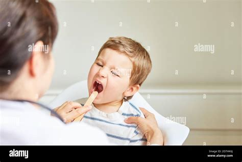 Pediatrician Examines Child With Tonsillitis Or Sore Throat With