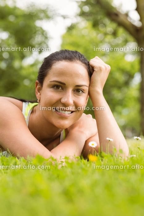 Smiling Fit Brunette Lying On Grass And Looking At Cameraの写真素材 110024268 イメージマート