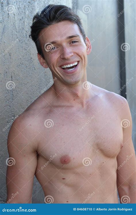 Smiling Shirtless Male Model Flirting Against Gray Background Stock