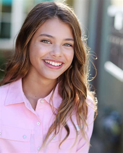A Girl With Long Hair Wearing A Pink Shirt And Smiling At The Camera